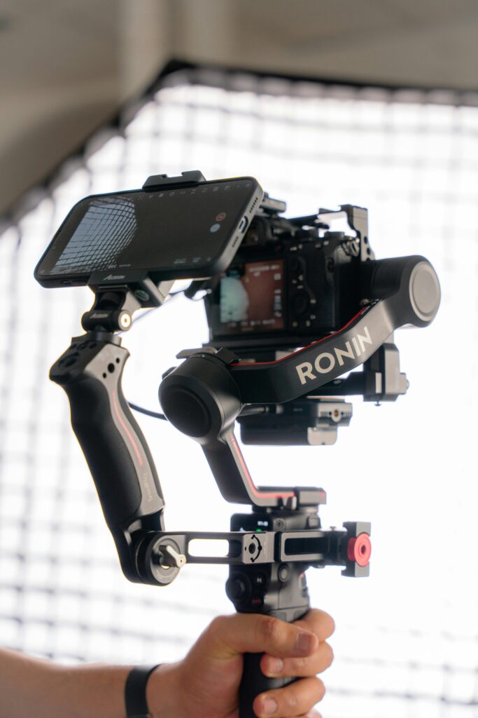 A videographer uses a Ronin gimbal for steady camera shots, showcasing advanced filming technology.